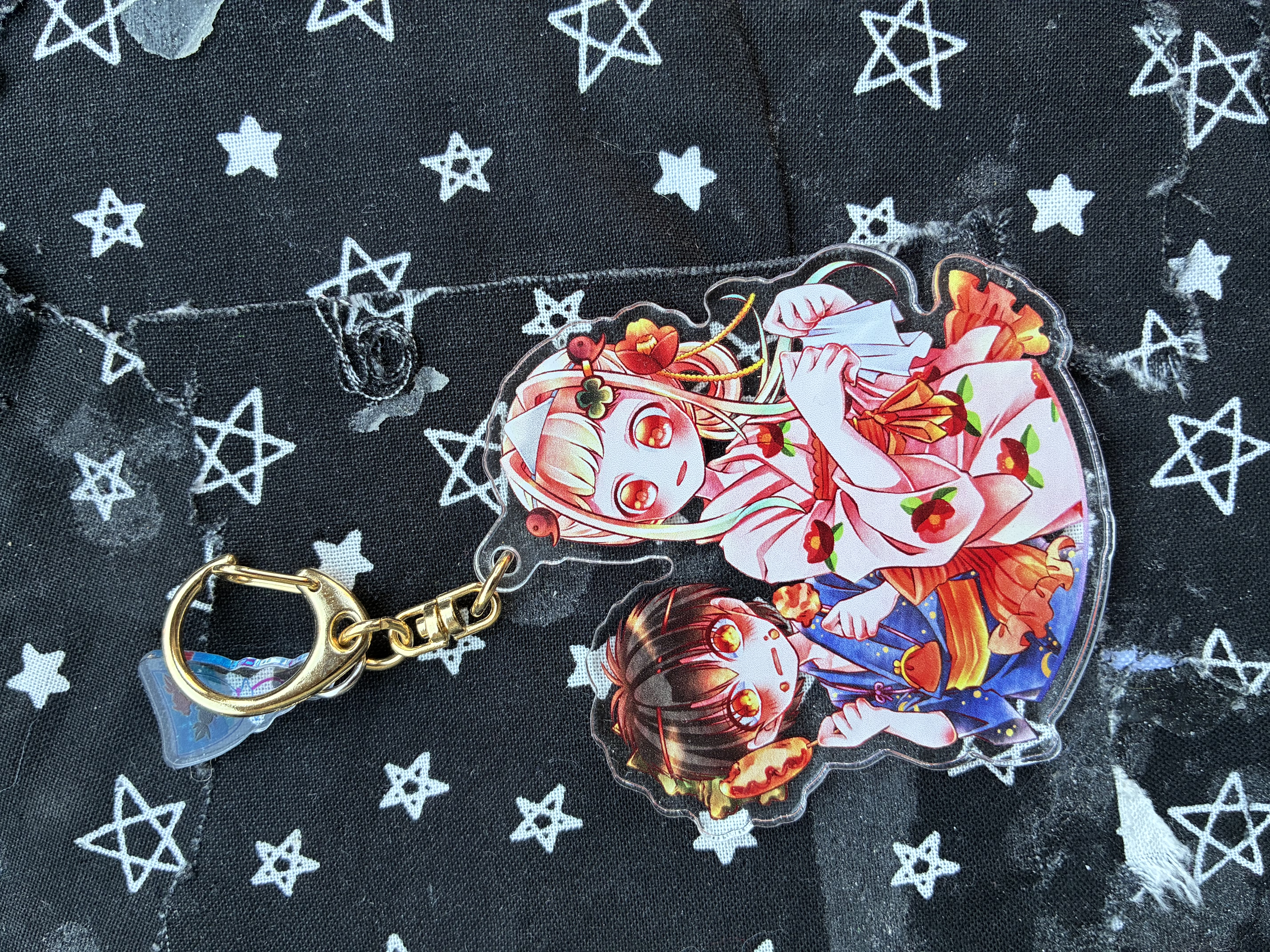 Acrylic charm of Jibaku shounen hanako summer lights arc Nene and little Amane. Nene is holding a napkin and little Amane is embarrassed with food on his face.